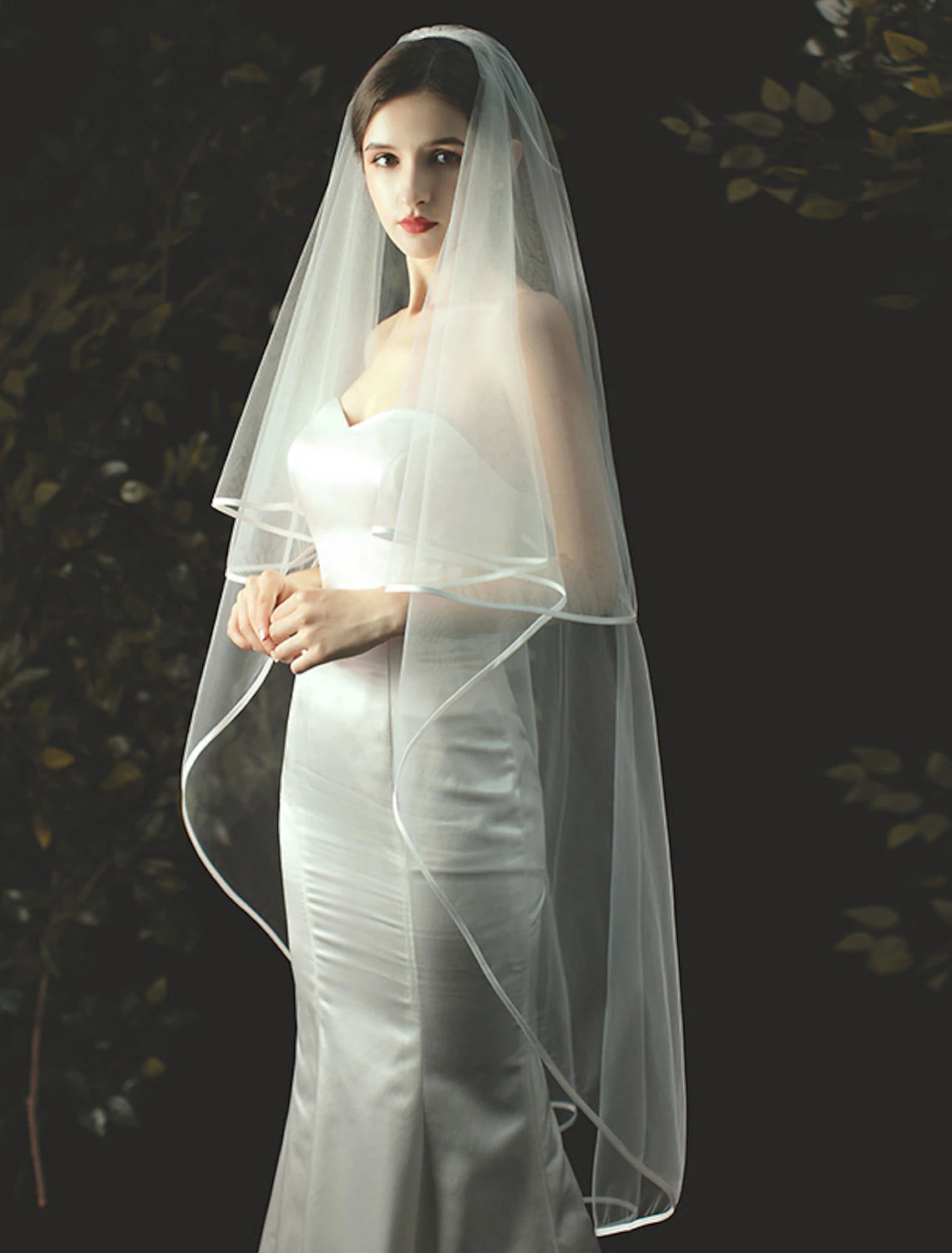 Side view of a bride in a two-tier solid tulle wedding veil.