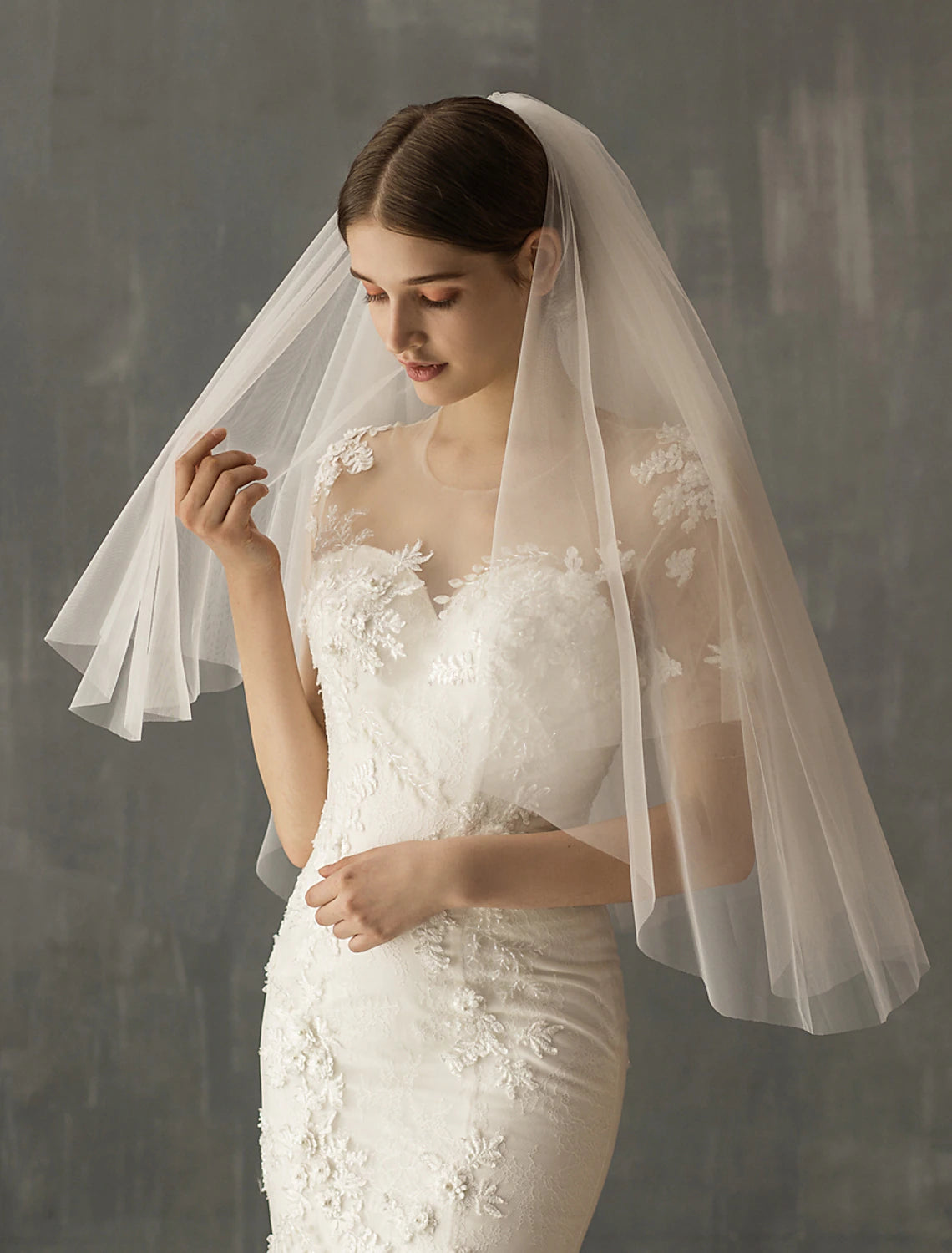 Bride wearing an elegant two-tier elbow length wedding veil.