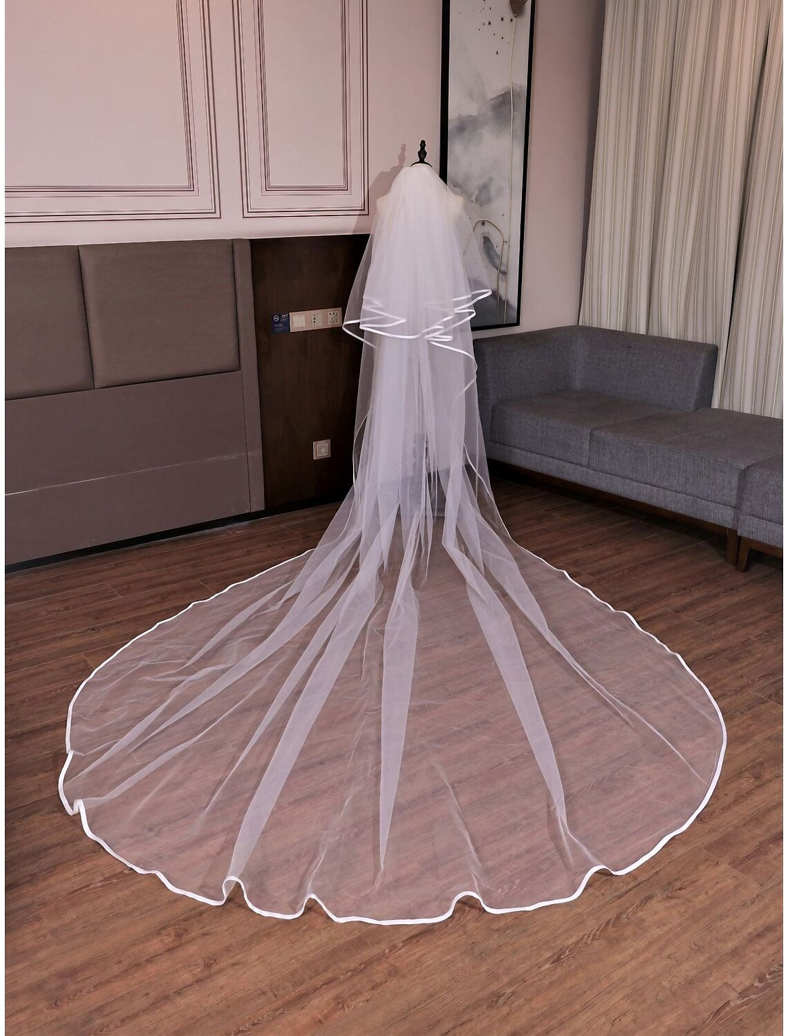 Elegant two-tier cathedral wedding veil made of delicate tulle, draped gracefully.