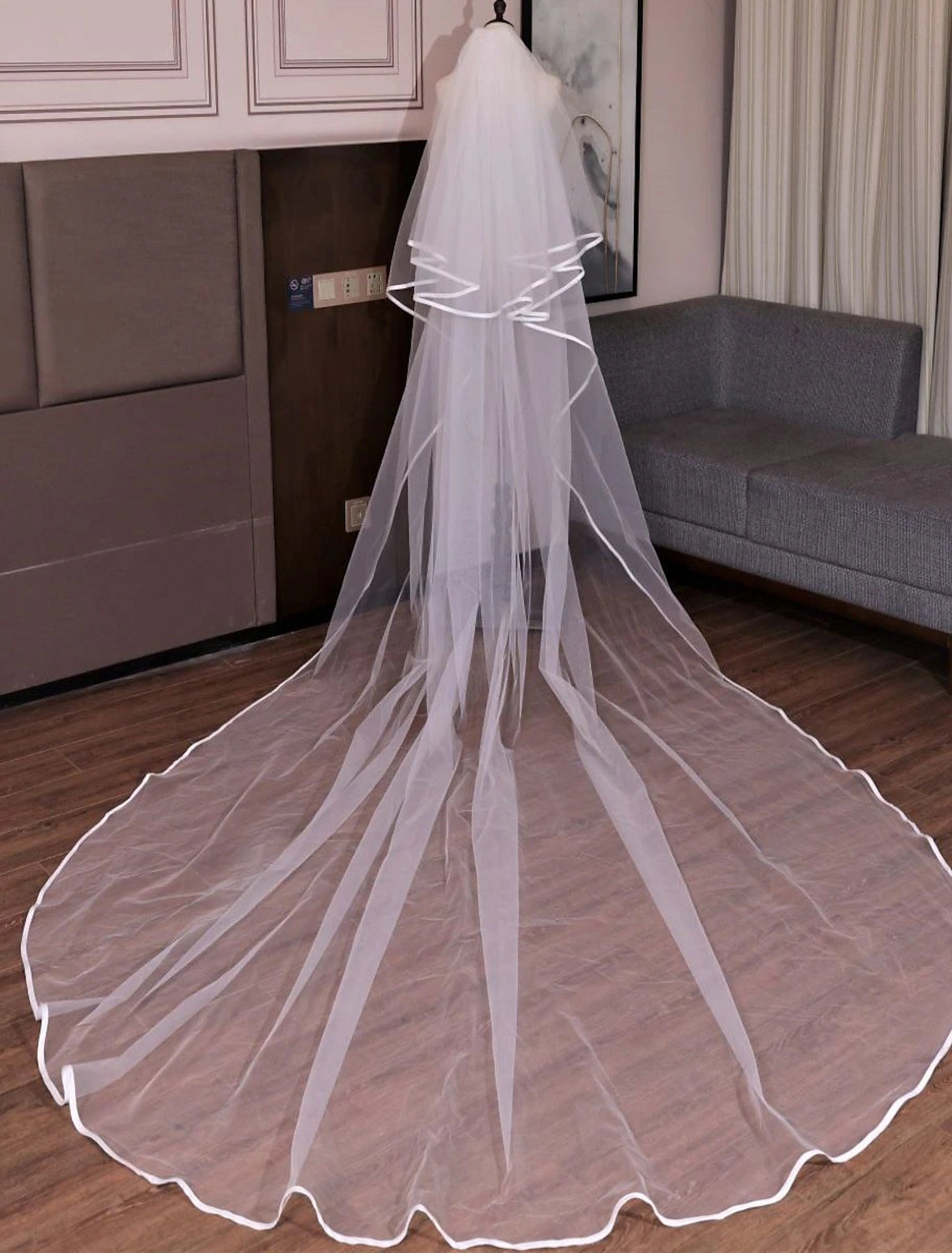 Bride wearing a long two-tier tulle wedding veil, showcasing its impressive cathedral length.