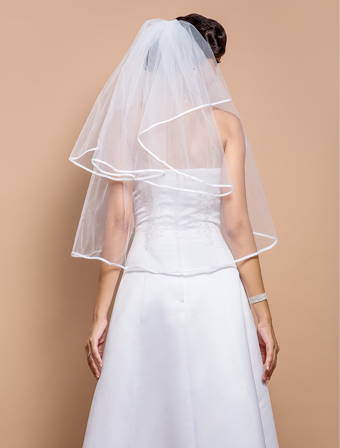 Close-up of the delicate ribbon edge and rhinestone details on the wedding veil.