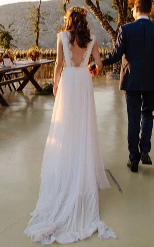 Back view of a bride wearing an A-line V-neck chiffon lace wedding dress with an open back.