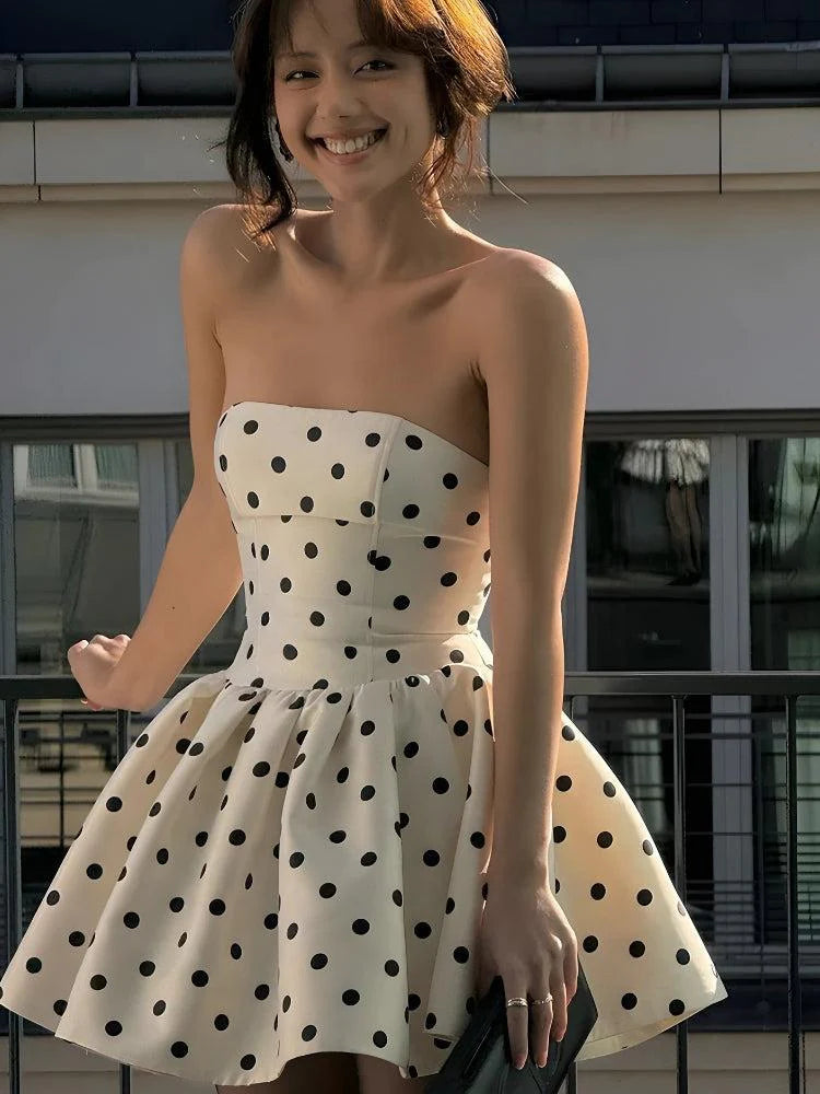 Close-up of the bow and polka dot pattern on the V-neck mini dress.
