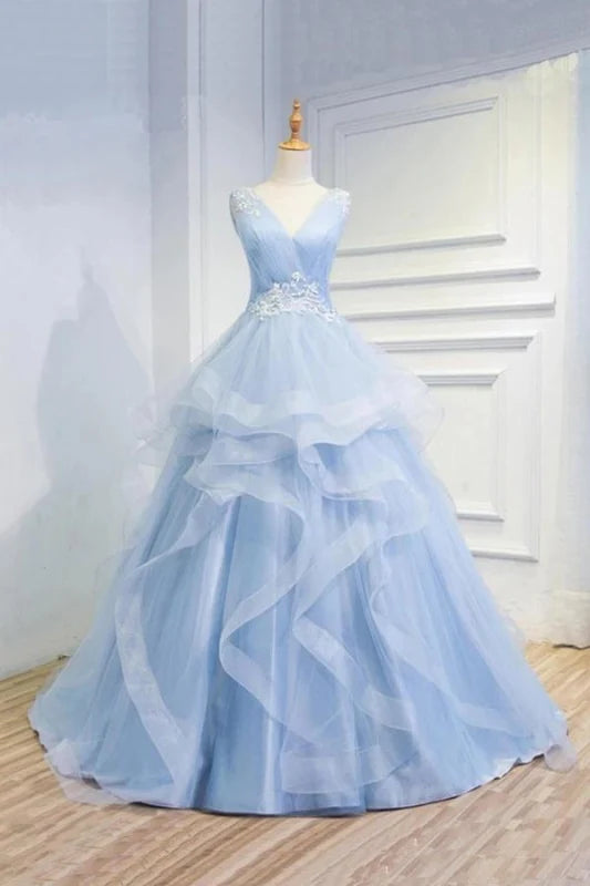 Model wearing an elegant V-neck tulle prom or quinceanera dress with appliques.