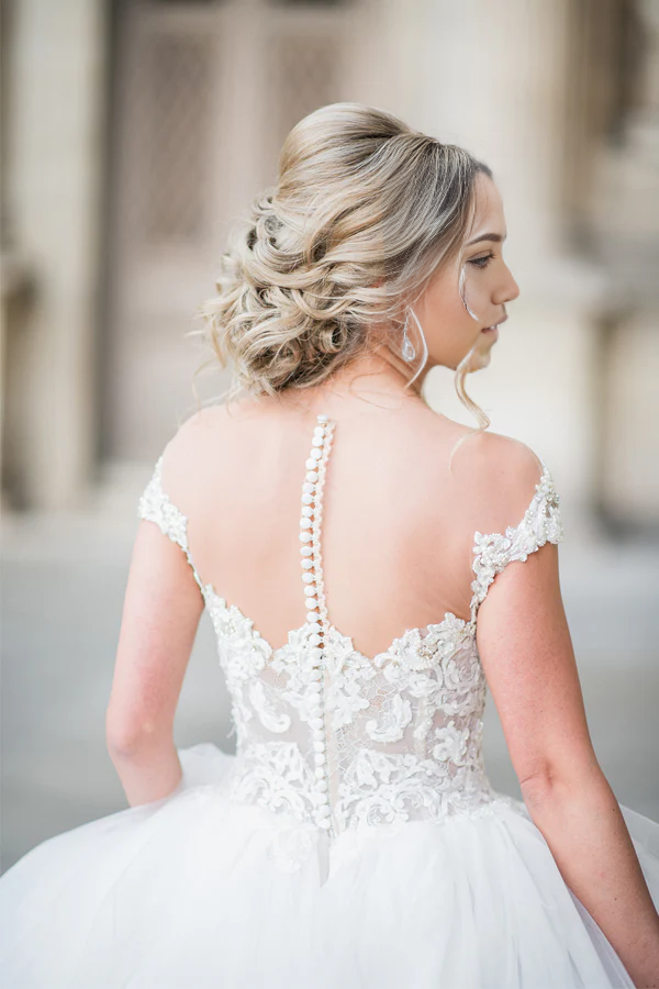 Side profile of the elegant ball gown wedding dress with cap sleeves.