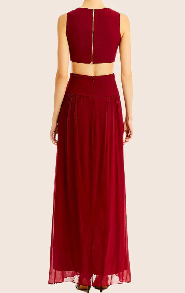 A woman posing in a flowing V-neck spaghetti strap formal dress.