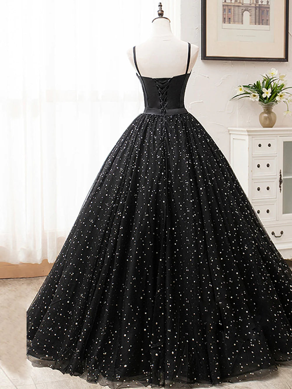 Side view of a woman in an elegant V-neck glitter long prom dress.