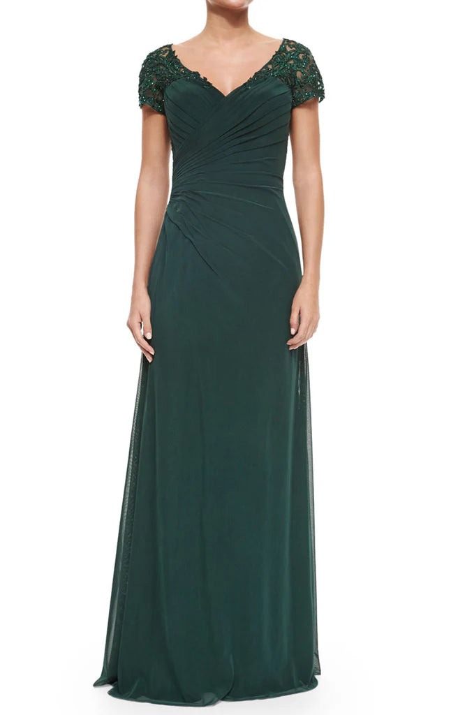 Elegant woman wearing a long V-neck lace and chiffon Mother of the Bride dress with sleeves.