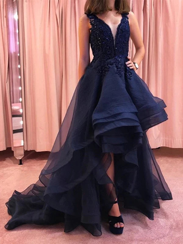 Woman wearing an elegant navy V-neck lace high-low prom gown.