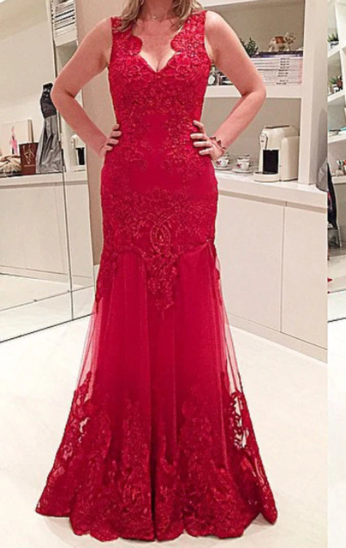 Woman wearing an elegant V-neck lace prom gown with an open back.