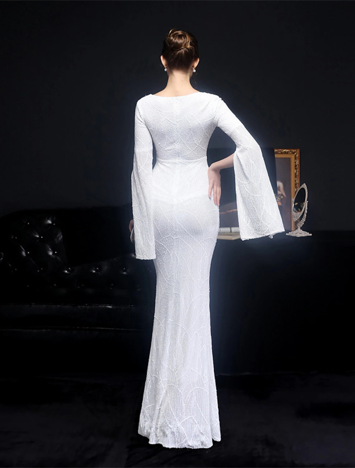 Full length view of a dazzling long sleeve evening dress.
