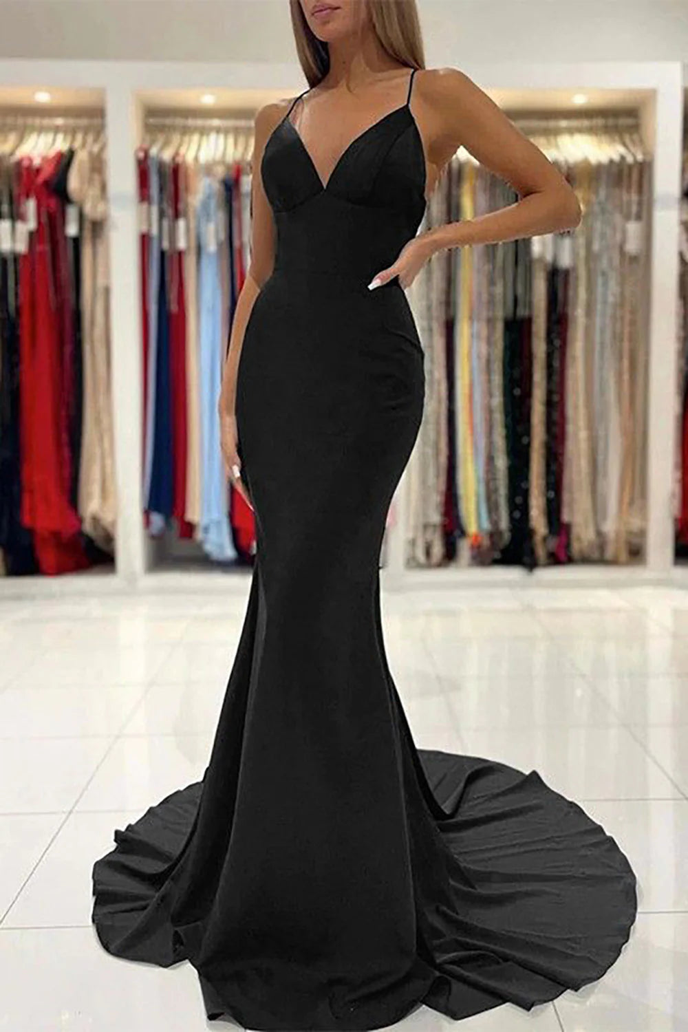 Elegant V-neck mermaid prom dress with spaghetti straps on a model.