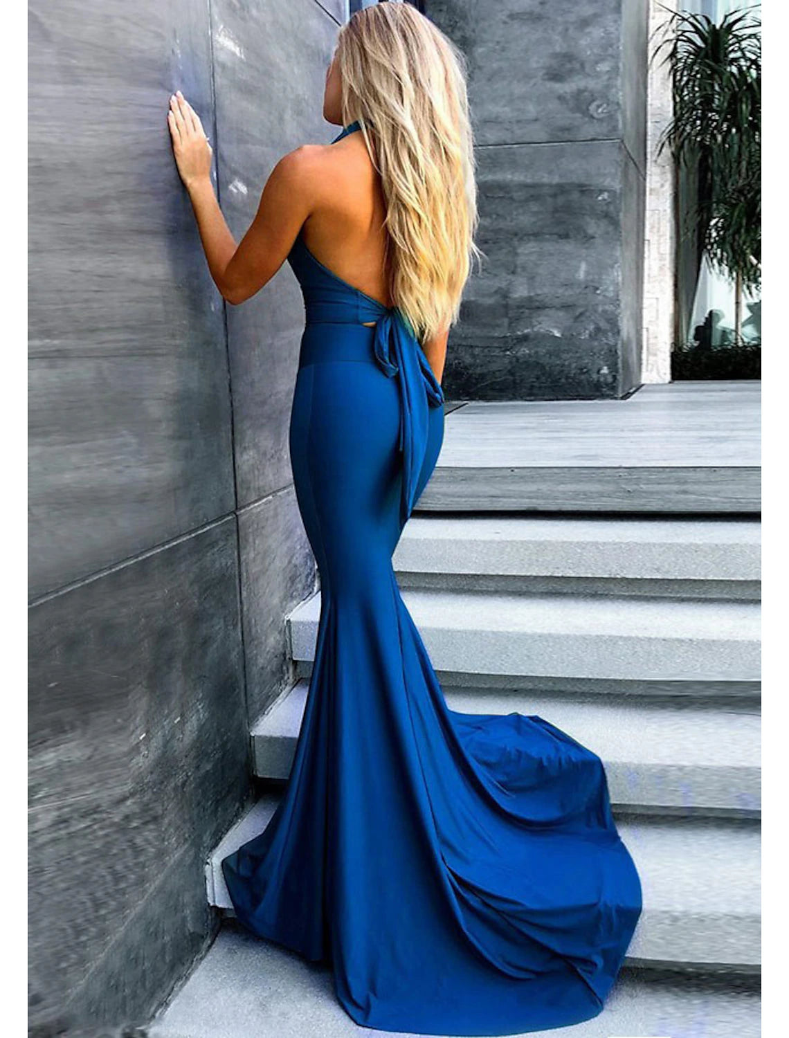 Back view of a sophisticated mermaid trumpet prom dress with a flowing court train.