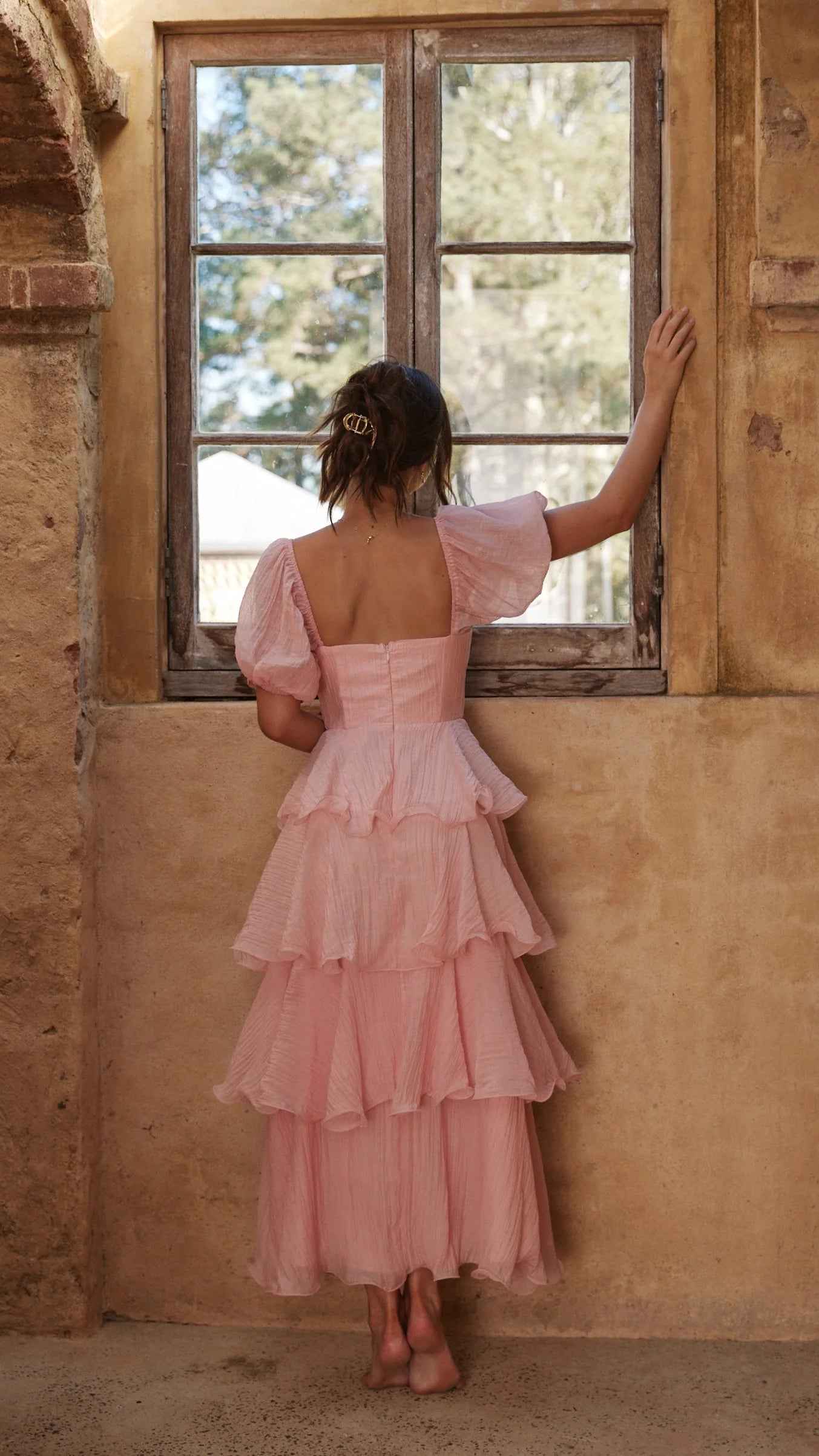 Side view of a woman wearing an A-line maxi dress with V-neck.