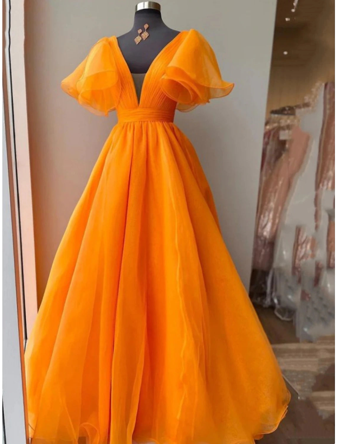 Elegant V-neck short sleeve ball gown in organza with pleats and ruffles, front view.