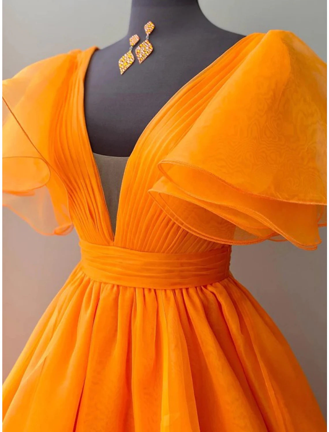 Side view of the floor-length ball gown, highlighting the ruffled details and silhouette.