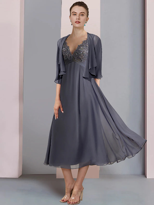 A woman wearing an elegant two-piece V-neck short sleeve chiffon lace tea length mother of the bride dress with a wrap.