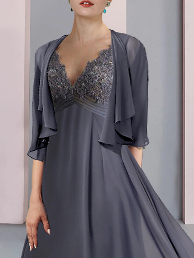 A woman posing in an elegant two-piece V-neck short sleeve chiffon lace tea length mother of the bride dress.