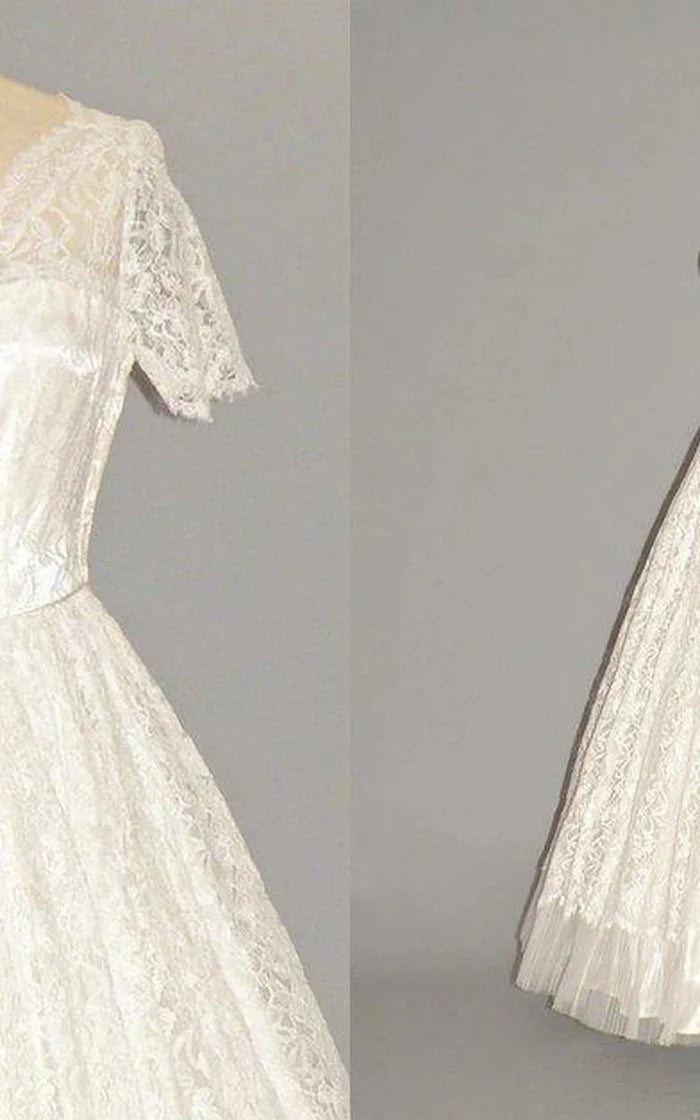 Full-length view of a bride posing in a beautiful short sleeve wedding dress.