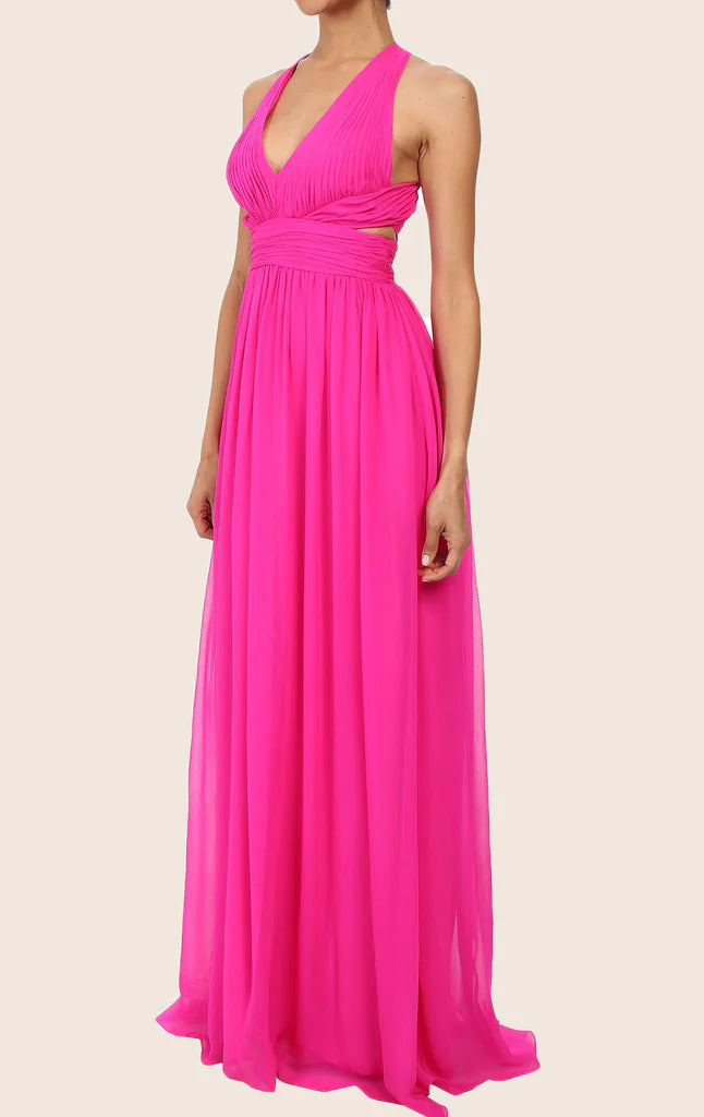 Side profile of a woman wearing a blush chiffon maxi dress with spaghetti straps.
