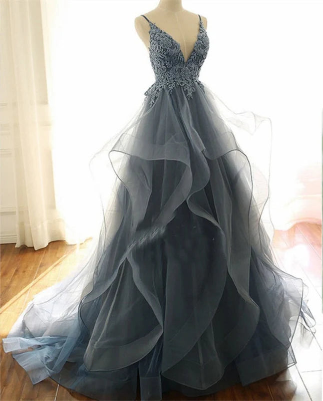 Side view of a V-neck formal gown with spaghetti straps and ruffled details.