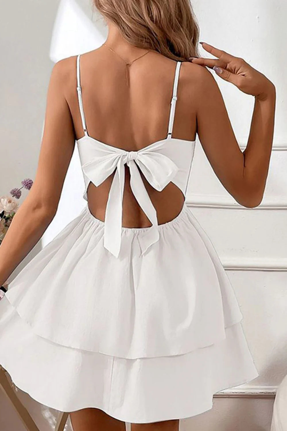 Side view of woman in V-neck spaghetti strap formal gown.