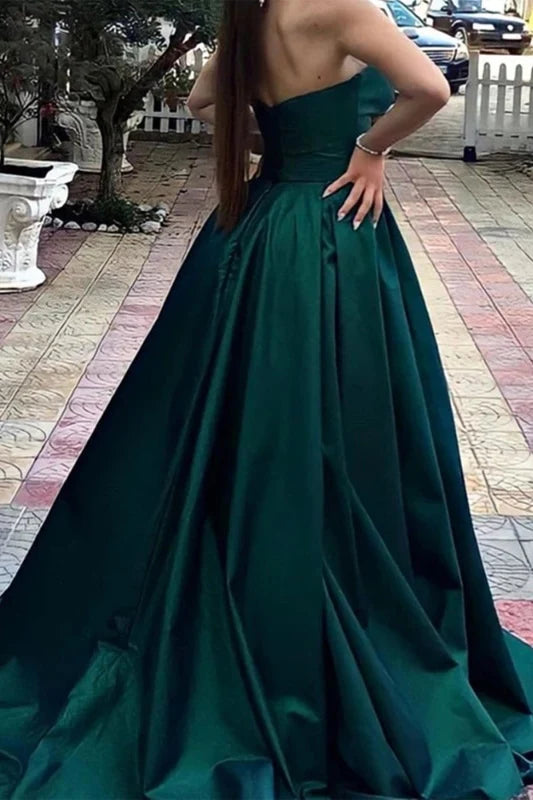 Woman posing in a V-neck strapless satin long prom dress.