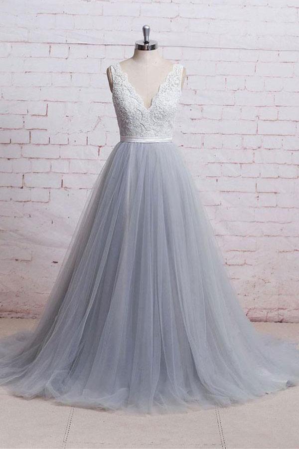 Model wearing an elegant V-neck lace bodice prom dress with a flowing tulle train.