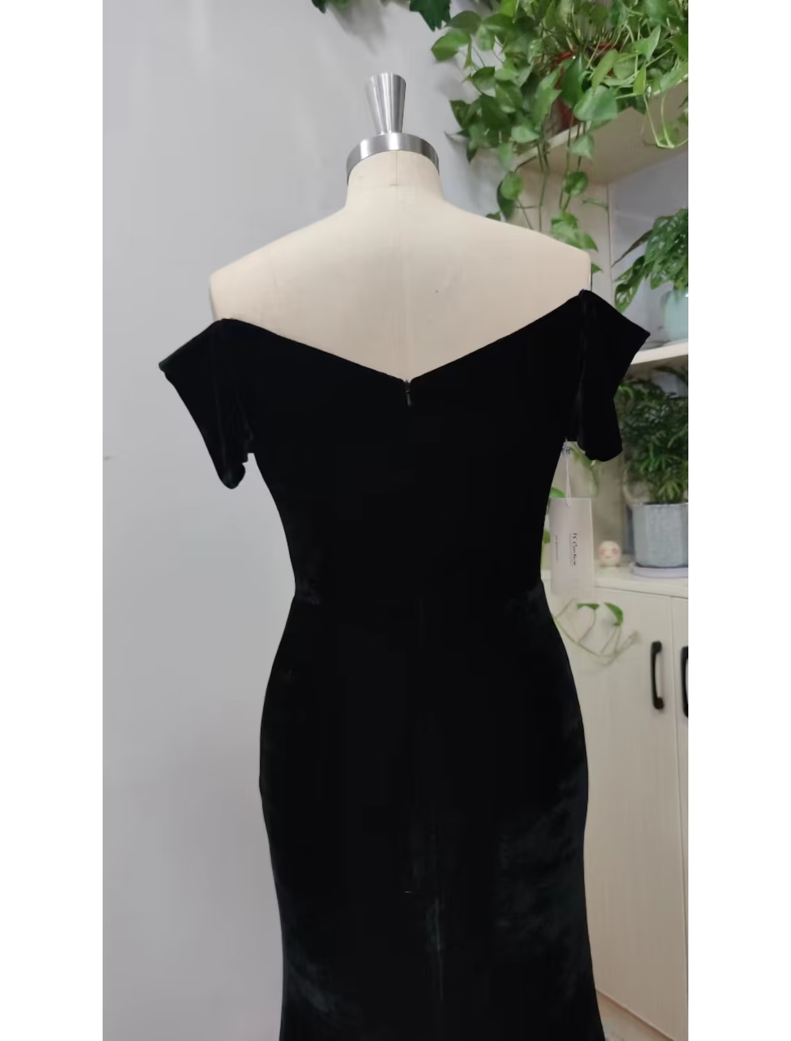 Close-up of the V-neckline and short sleeves of the black velvet evening dress.