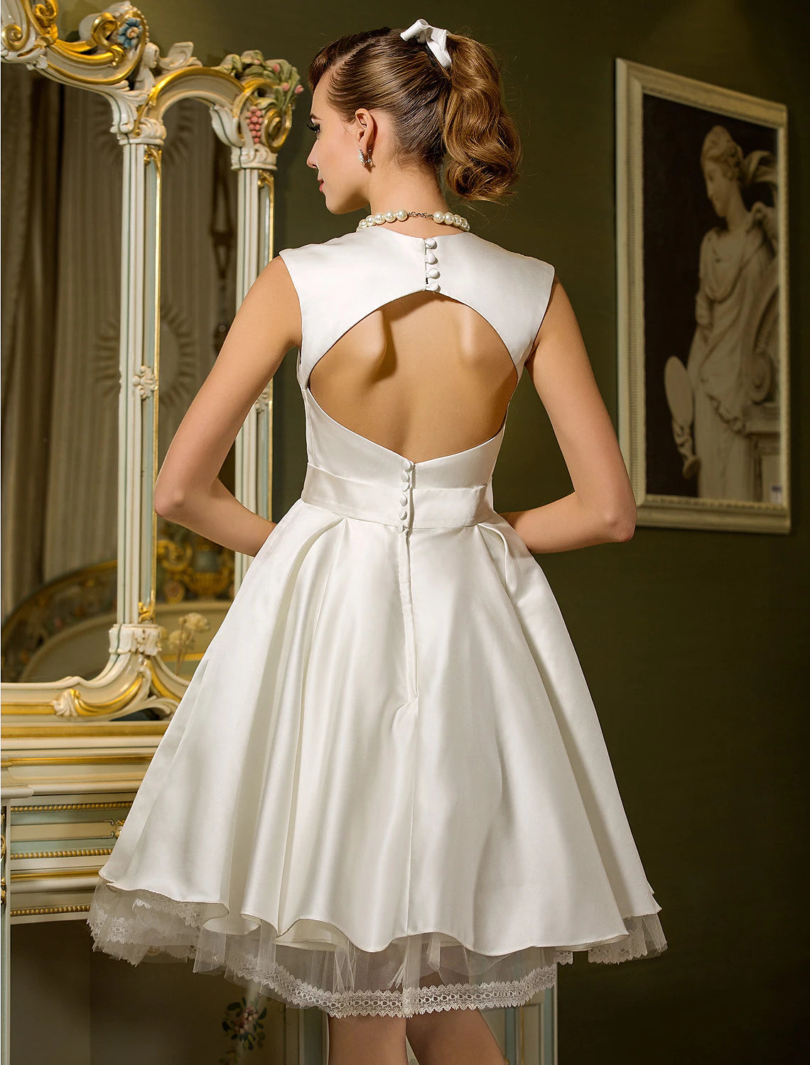 Full length view of the white satin knee-length wedding dress.