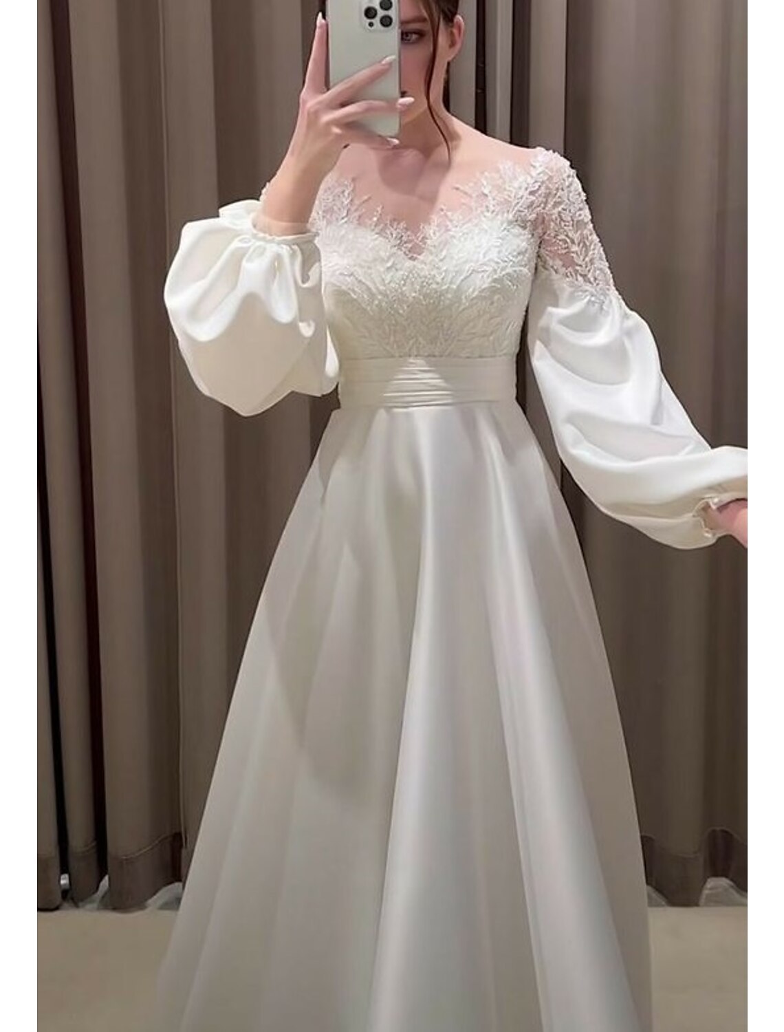 Elegant bridal gown featuring a V-neck, long sleeves, and intricate appliques.
