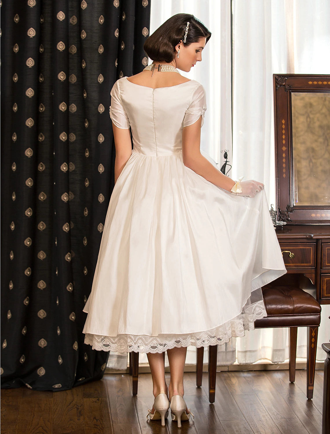 Side view of a white tea length bridal shower dress, showcasing the A-line silhouette.