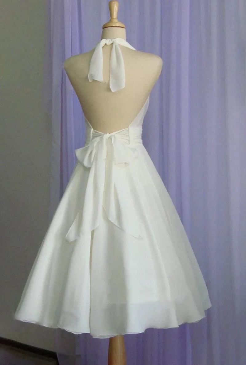 Bride wearing a vintage tea-length chiffon wedding dress with halter neckline.
