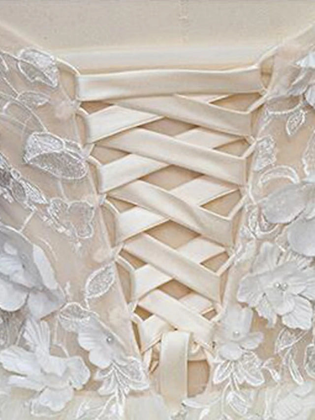 Close-up of lace and pearl appliques on a vintage wedding dress bodice.