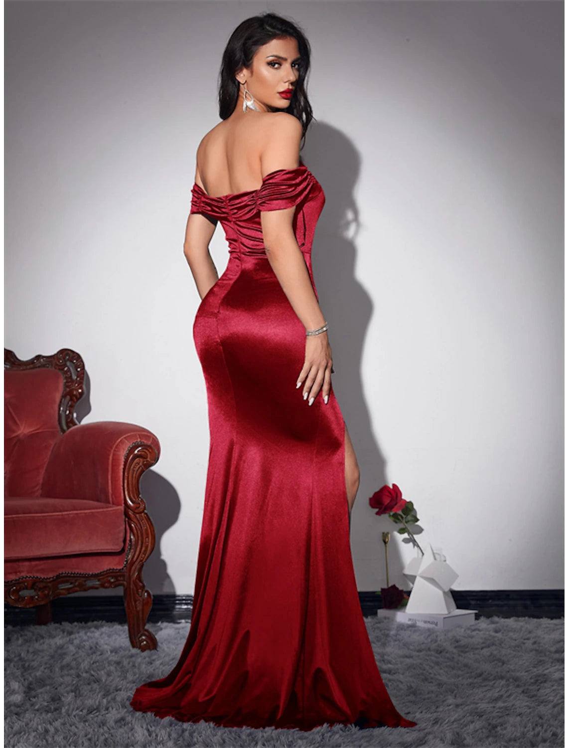 Model posing in a sleeveless off-shoulder mermaid dress.