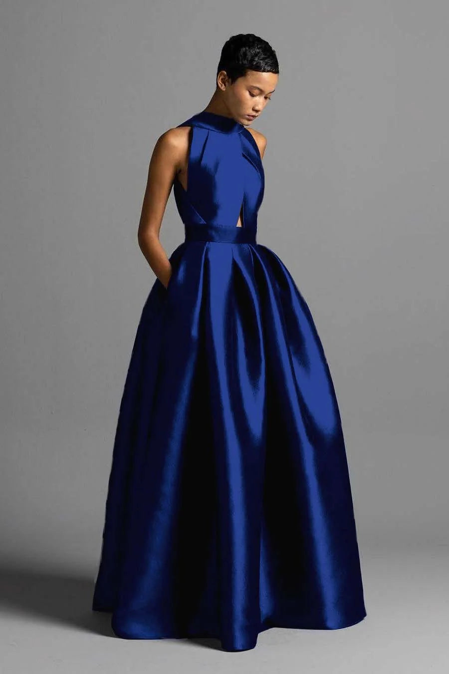 Woman wearing a vintage halter A-line pleated prom dress.