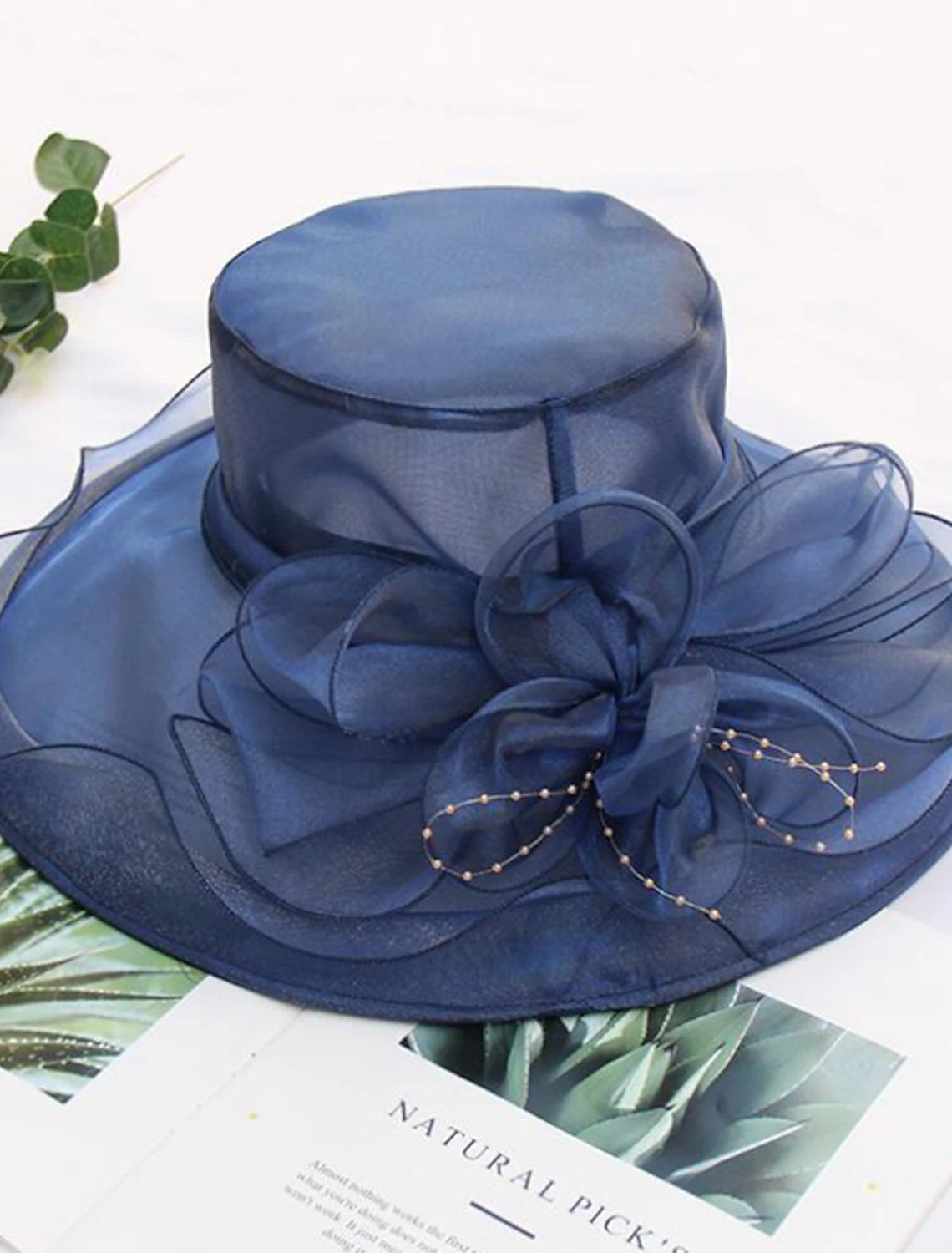 Elegant vintage straw hat with tulle and faux pearl flower, front view.