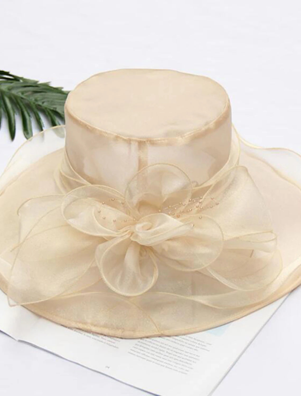 Vintage straw hat with delicate tulle and faux pearl detail, side view.