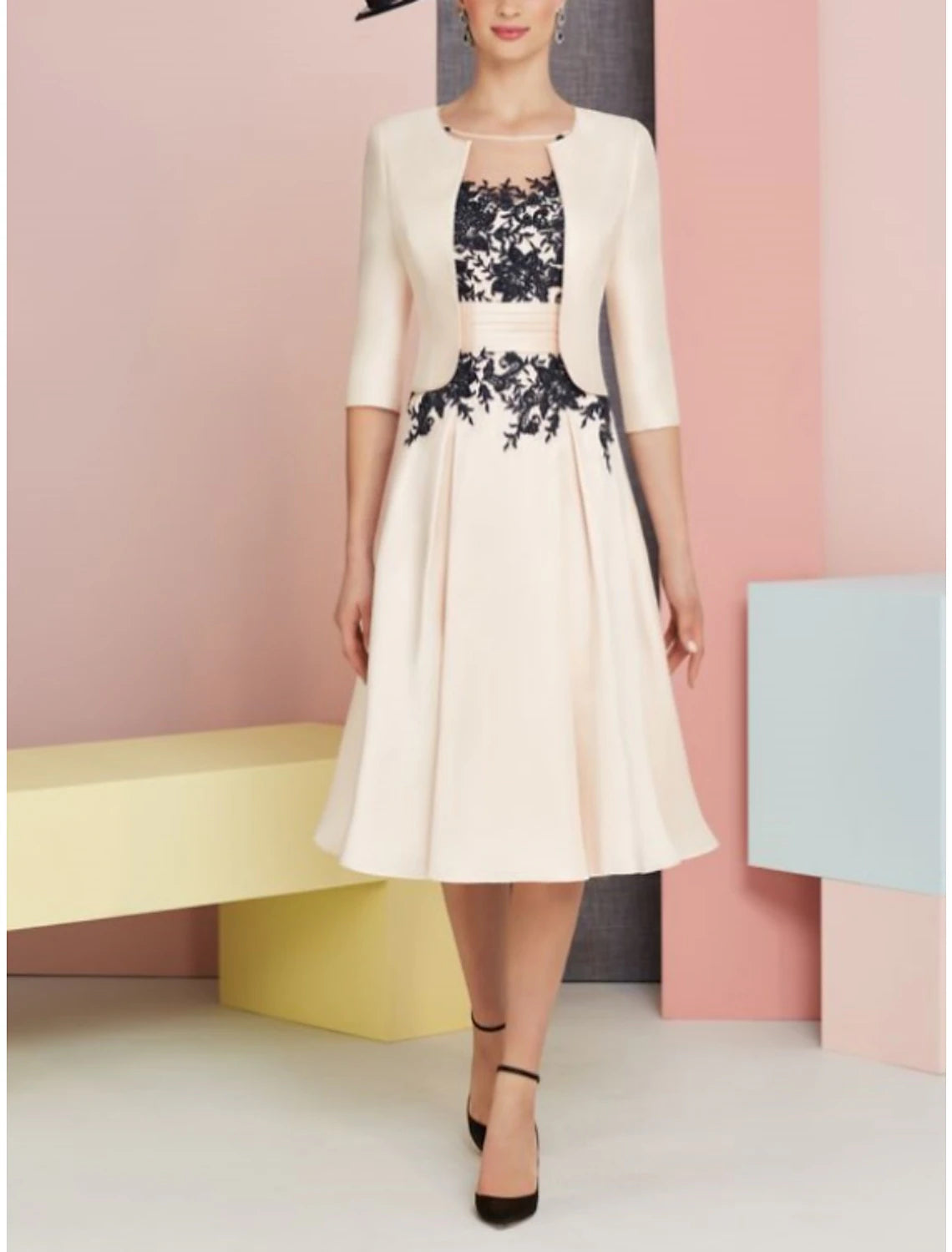 Close-up of the two-piece satin lace dress, highlighting the scoop neck and pleated skirt detail.