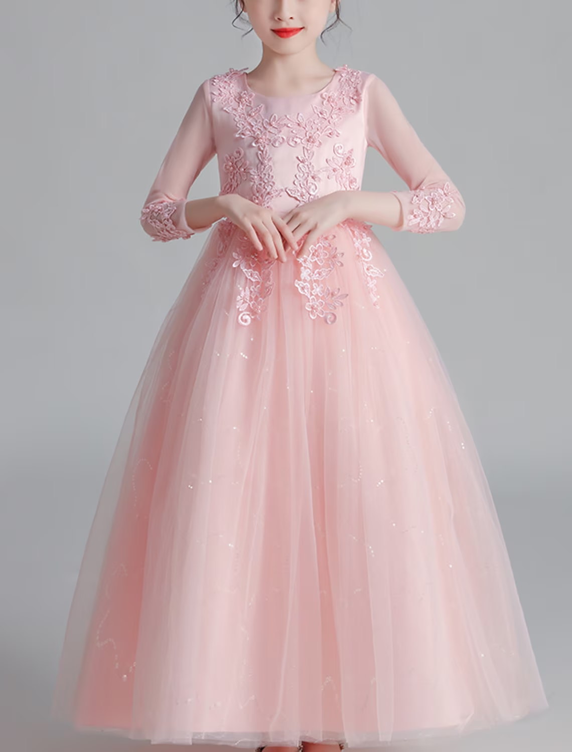 Back view of a little girl in a white maxi dress, showcasing the floral and bow details and 3/4 sleeves.