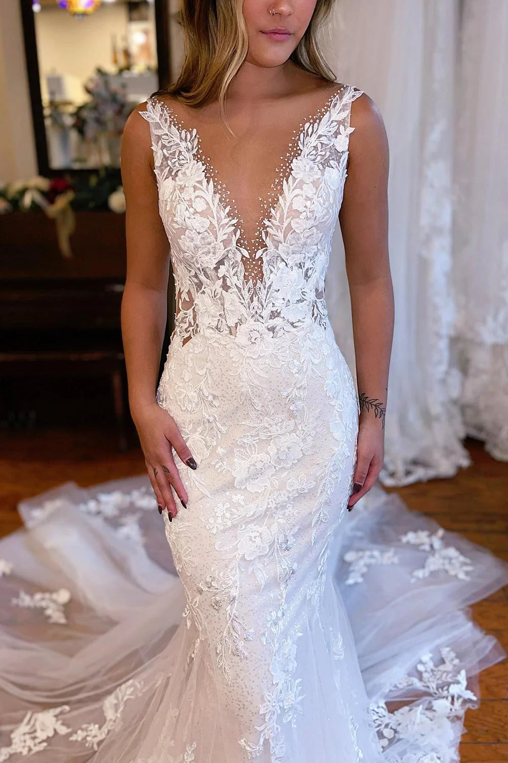 Side view of a bride wearing a white lace mermaid gown.