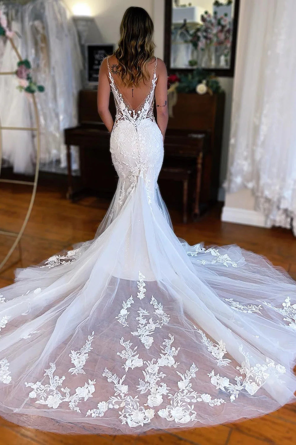 Close-up of intricate lace applique on a white wedding dress.