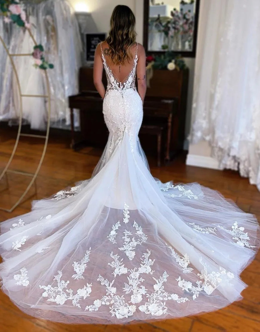 Back view of a white mermaid wedding dress, highlighting the chapel train and delicate appliques.