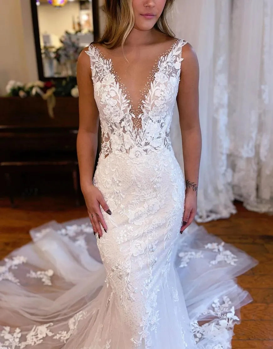 Side profile of a white mermaid wedding dress, featuring its silhouette and intricate appliques.