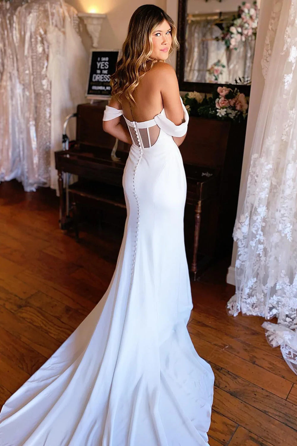 Elegant white mermaid wedding gown with off-shoulder neckline.