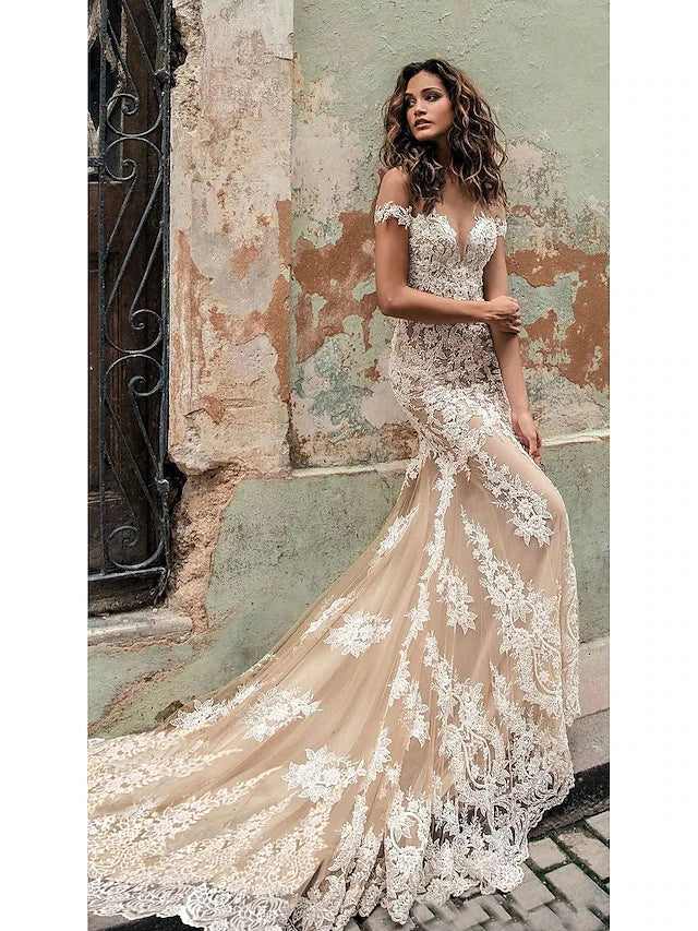 Elegant white mermaid wedding dress with off-shoulder neckline and cap sleeves, adorned with lace appliques.
