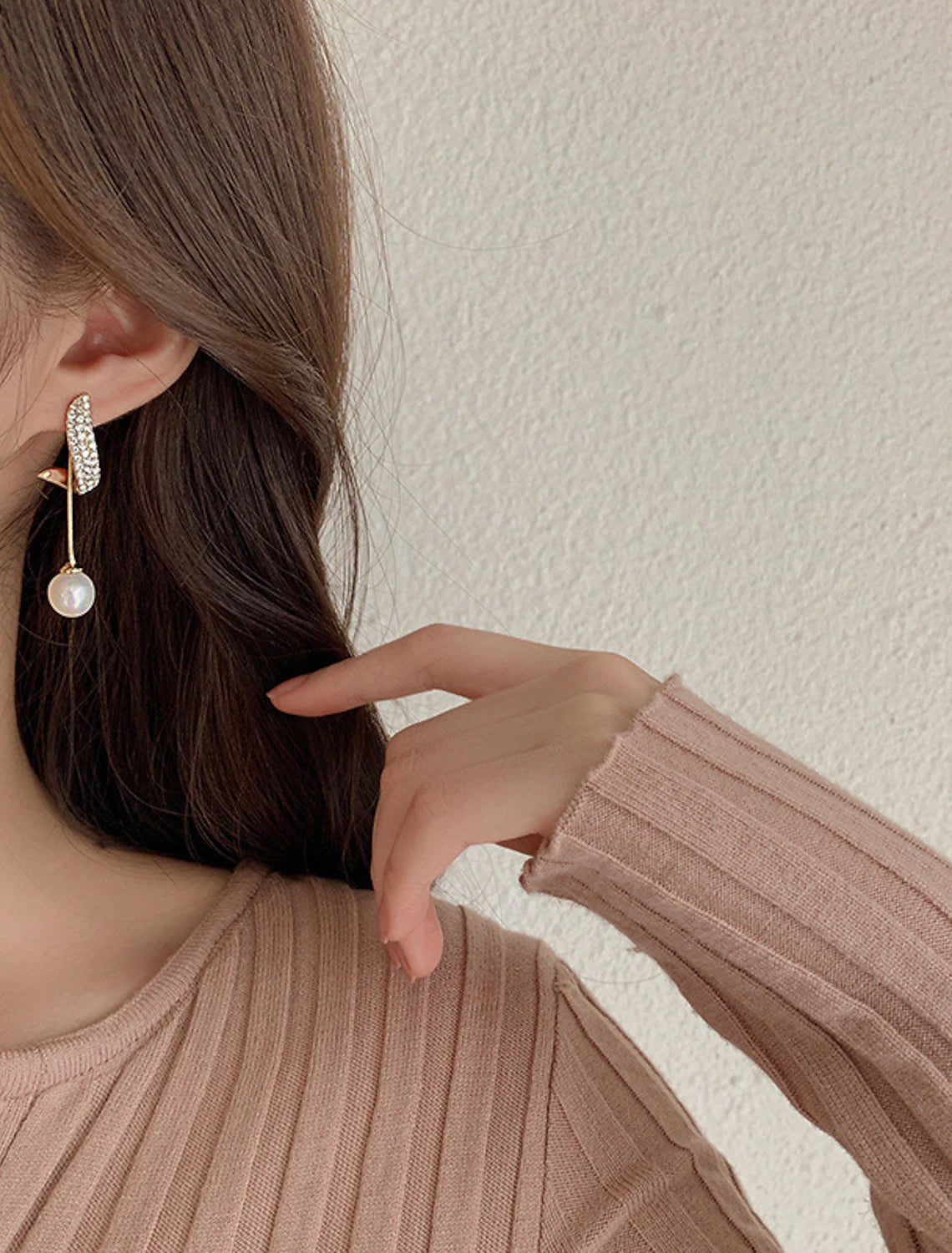 Close-up of white pearl drop earrings.