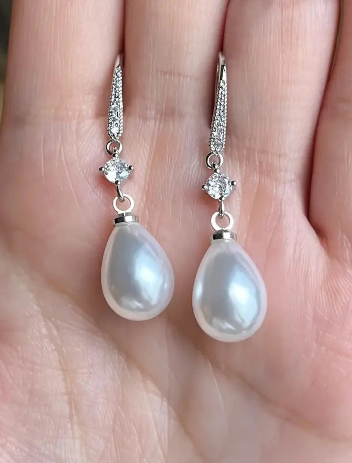 Pair of white pearl drop earrings with secure backings.