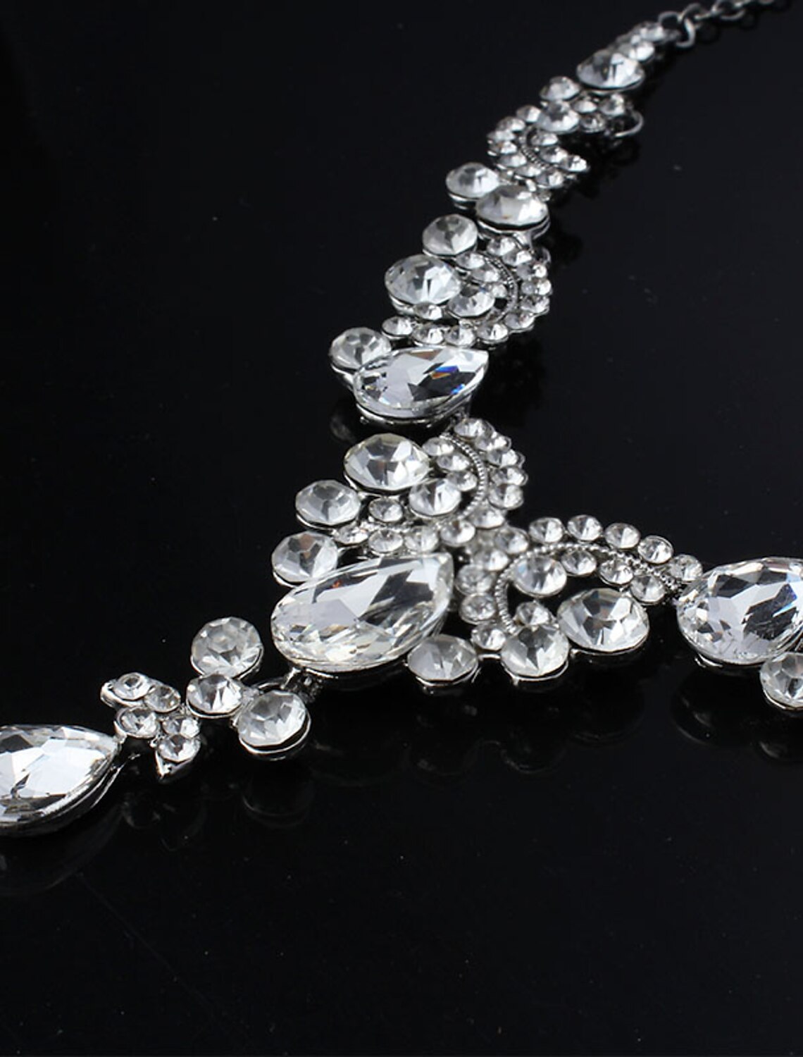 Close-up of the white rhinestone necklace with a pear drop design.