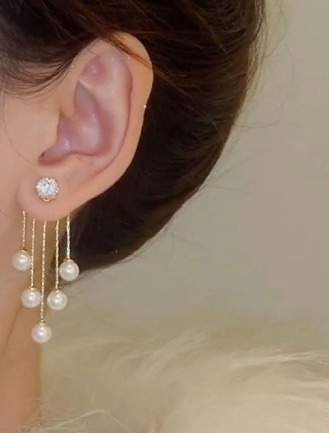 White tassel fringe drop earrings on a model.